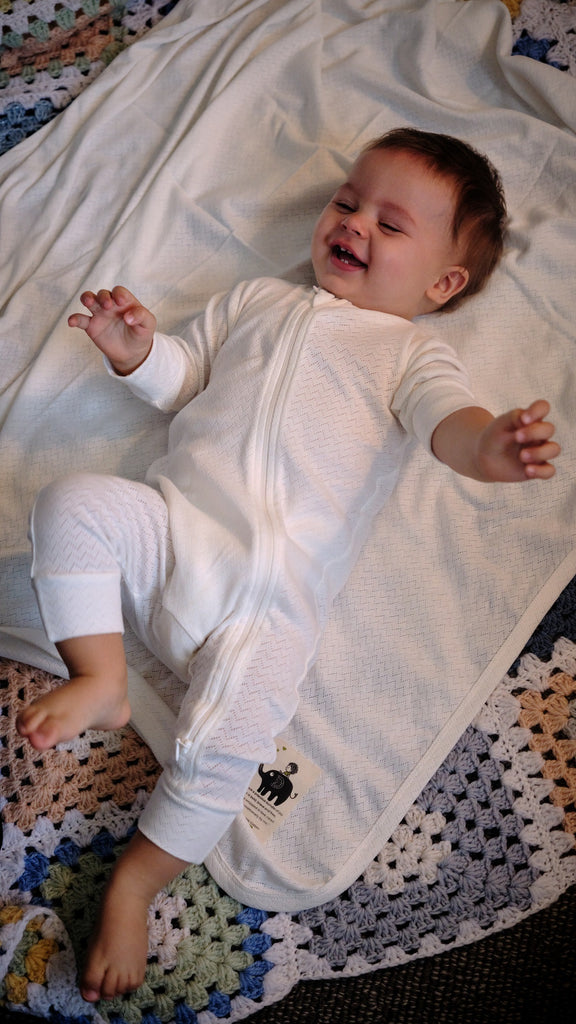 baby in organic cotton growsuit