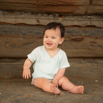 Baby wearing organic cotton mint green kimono bodysuit